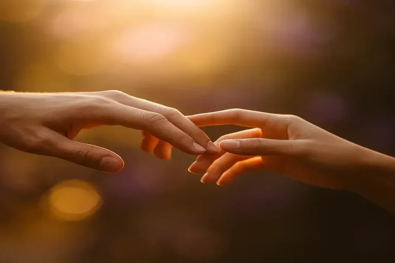 Deux mains se frôlent dans une lumière dorée, symbolisant la connexion émotionnelle et la communication sensorielle offertes par le CRDL, un instrument qui transforme le toucher en sons harmonieux pour créer du lien entre les êtres.